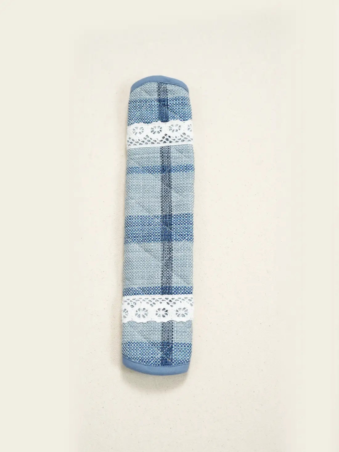 Close-up of a blue plaid fabric handle cover with white lace trim