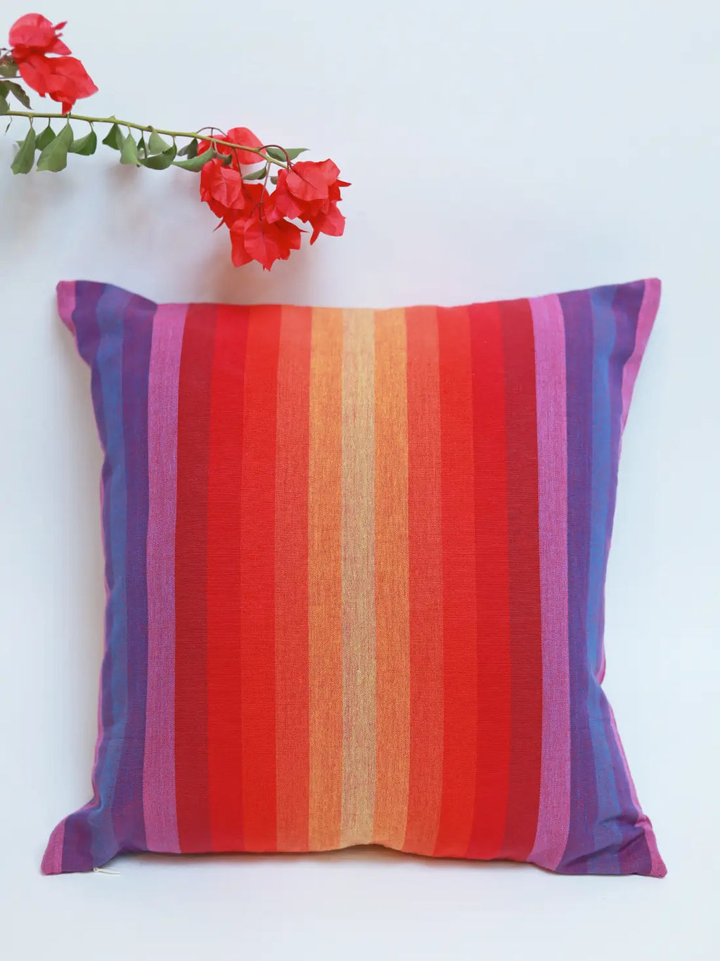 Red, orange and purple striped cushion cover on a white background