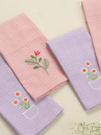 Close-up of pink and lavender waffle face towels with red tulip and orange daisy embroidery
