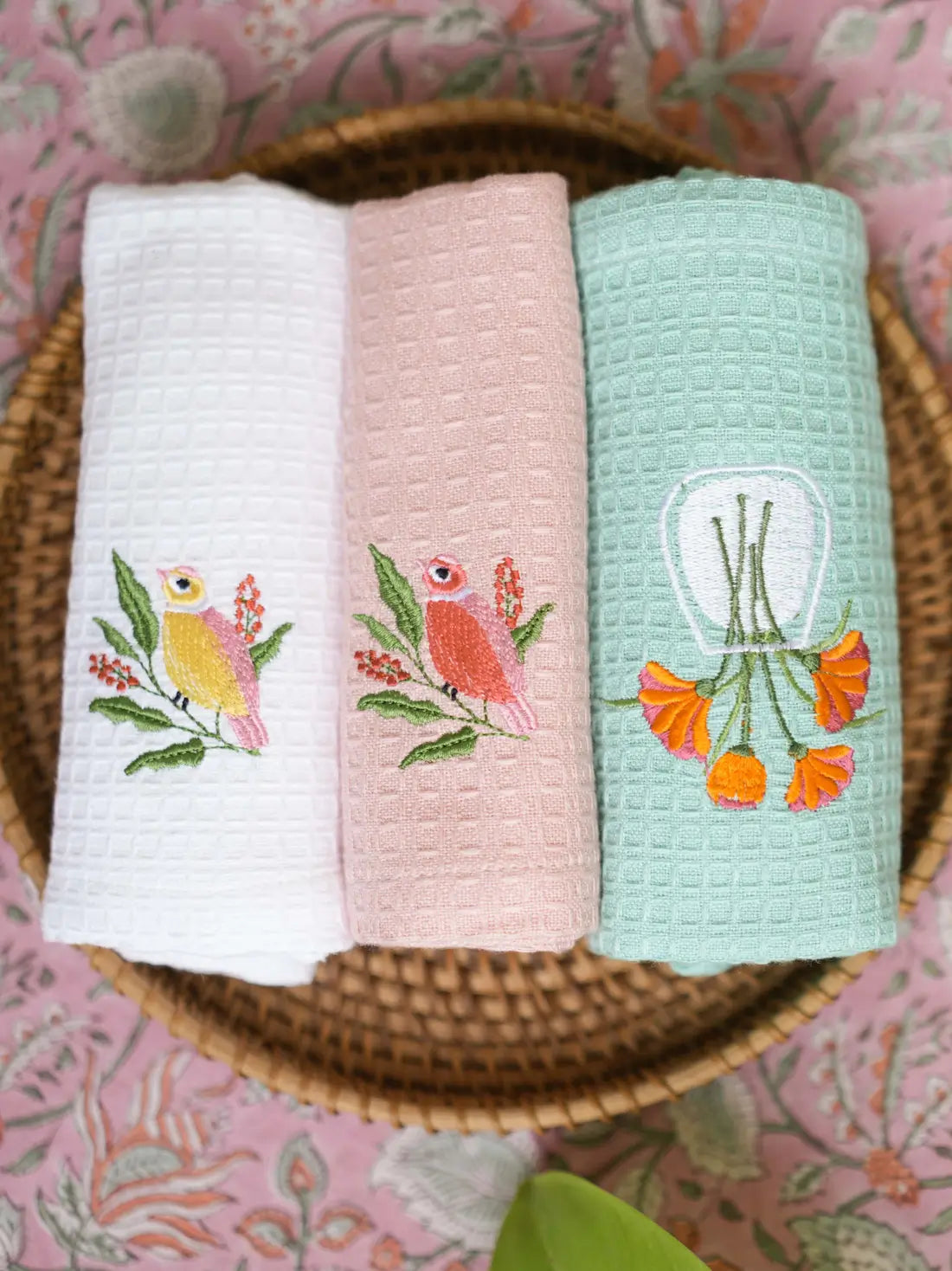 Three embroidered waffle hand towels in white, blush pink and mint green