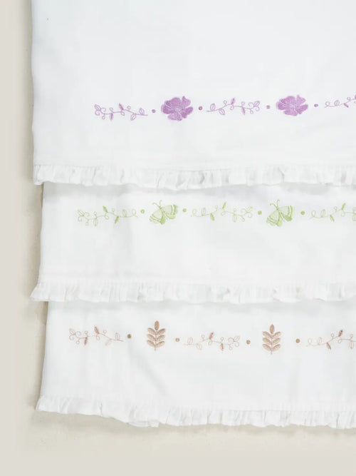 Three white Kerala Thorthu towels with purple, green and beige floral embroidery and ruffled edges
