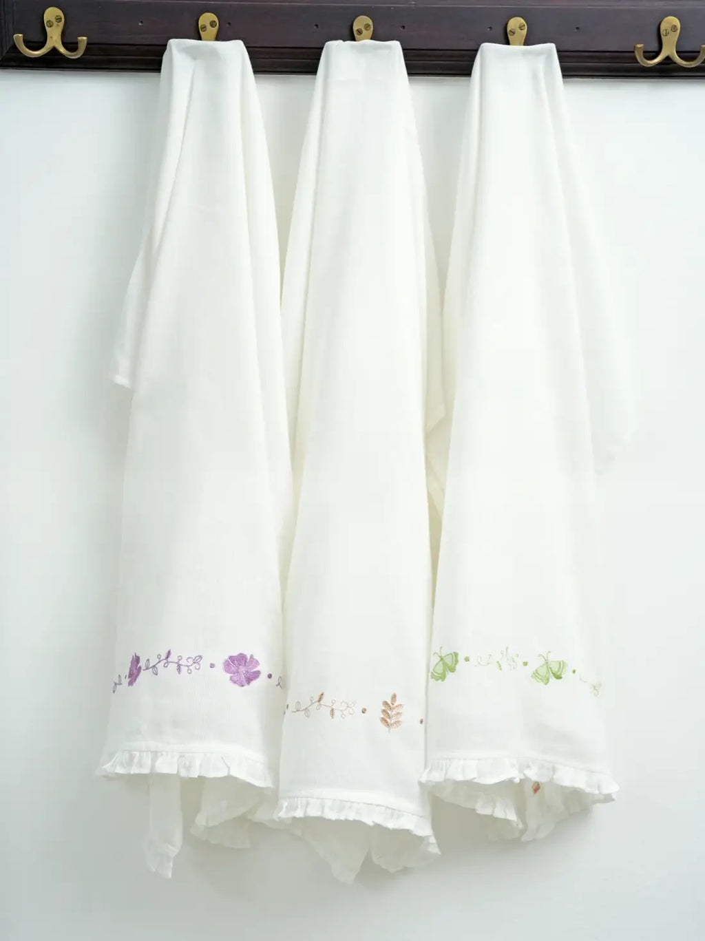 Floral Frills set of three white embroidered Kerala Thorthu towels hanging on hooks