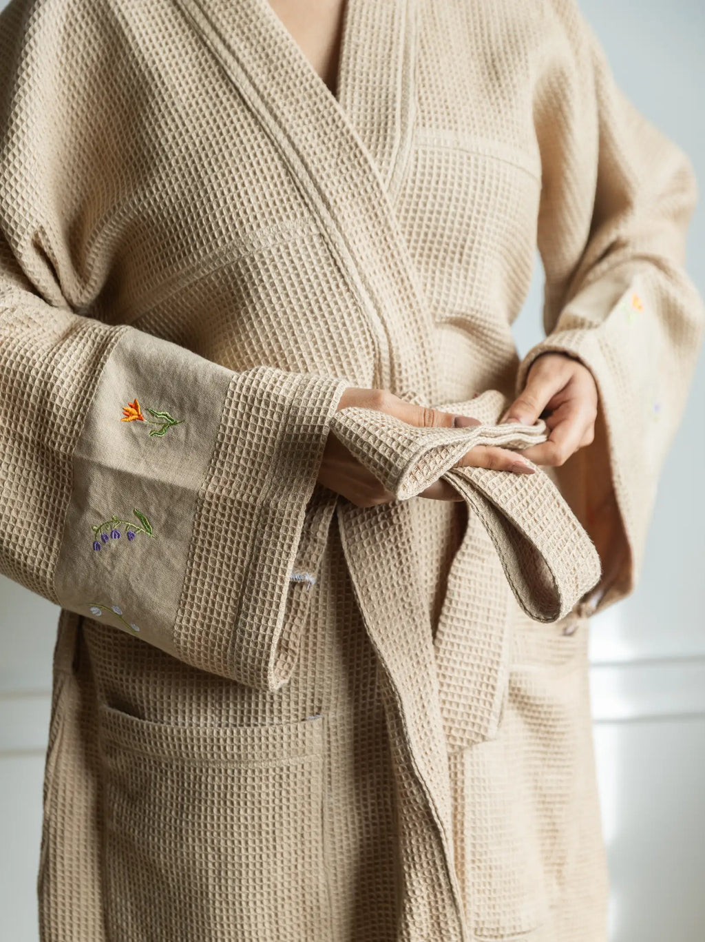 French beige waffle bath robe with a tie belt and floral embroidery on the wide cuffs