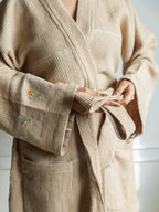 French beige waffle bath robe with a tie belt and floral embroidery on the wide cuffs