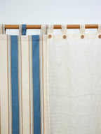 Ivory cream sheer checked curtain beside a blue striped curtain