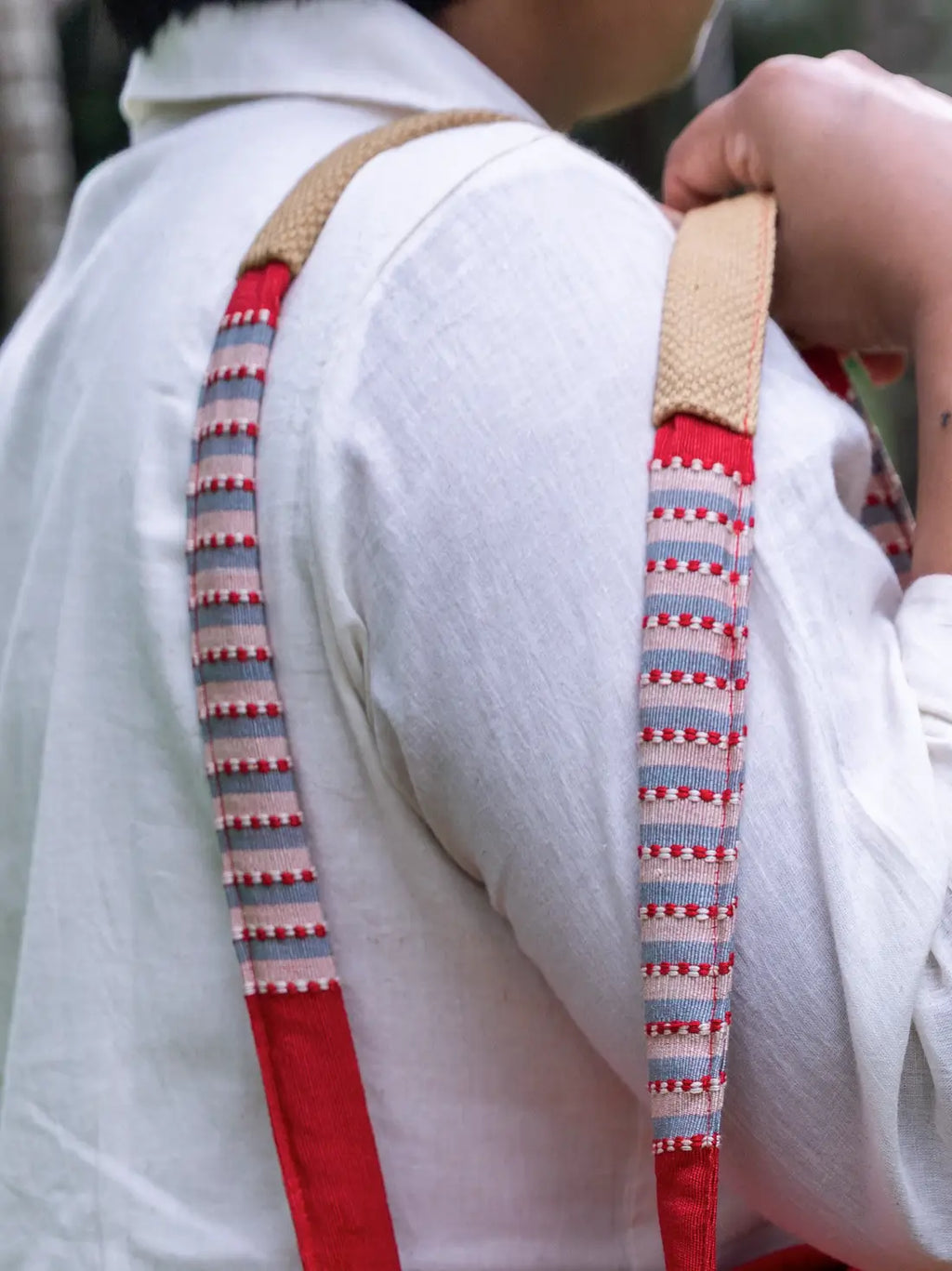 Close-up of the padded shoulder straps on a red and grey striped tote bag