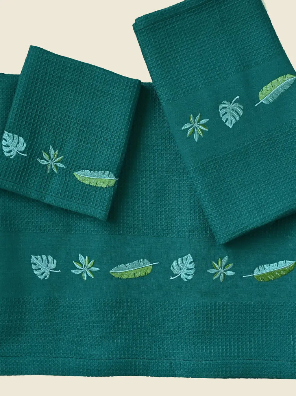 Teal green honeycomb bath, hand and face towels with tropical leaf embroidery
