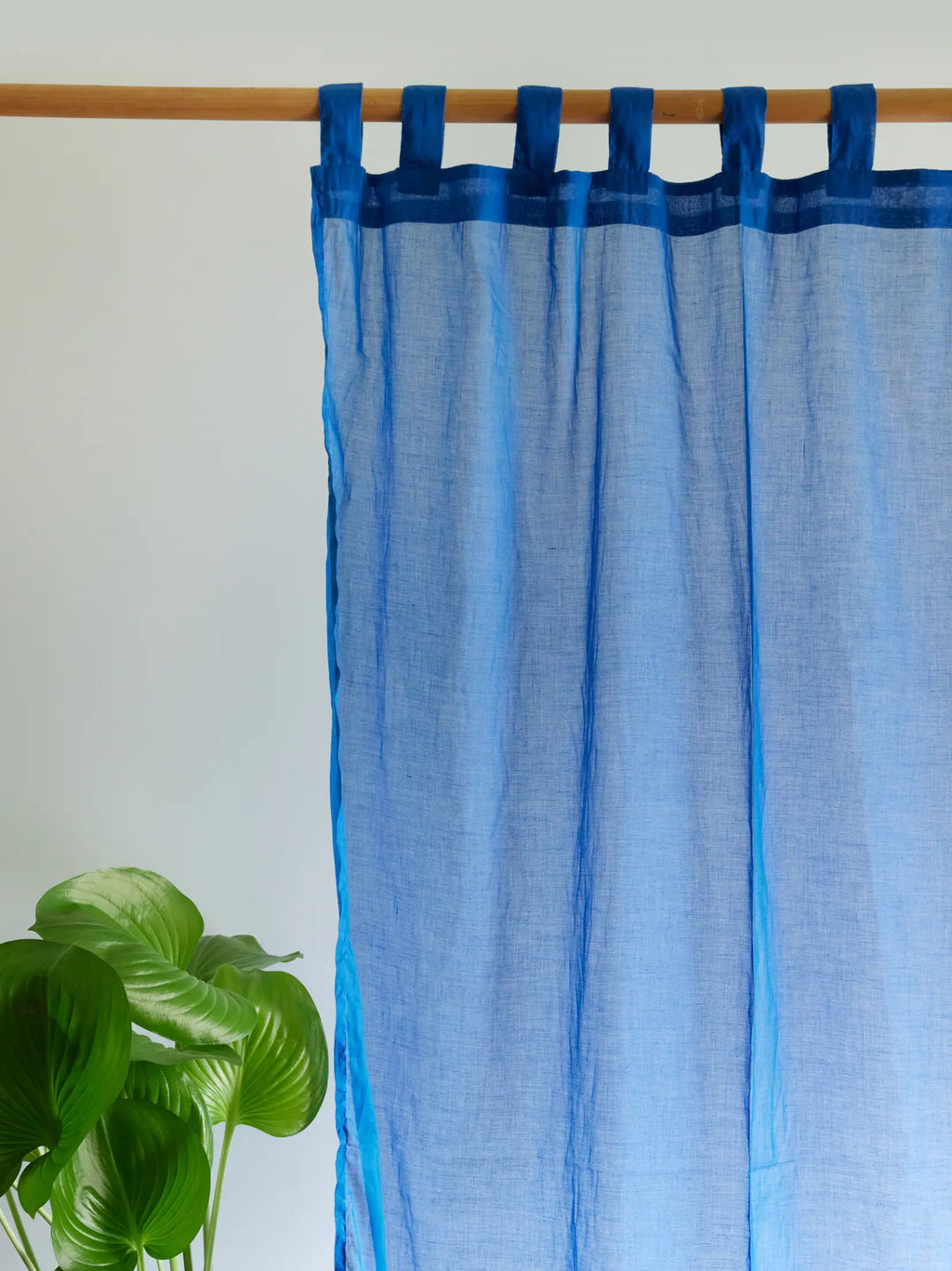 Blue sheer curtain with fabric loops and a dark blue top border
