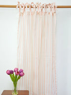 Full-length white sheer curtain with peach stripes and tie-top bows