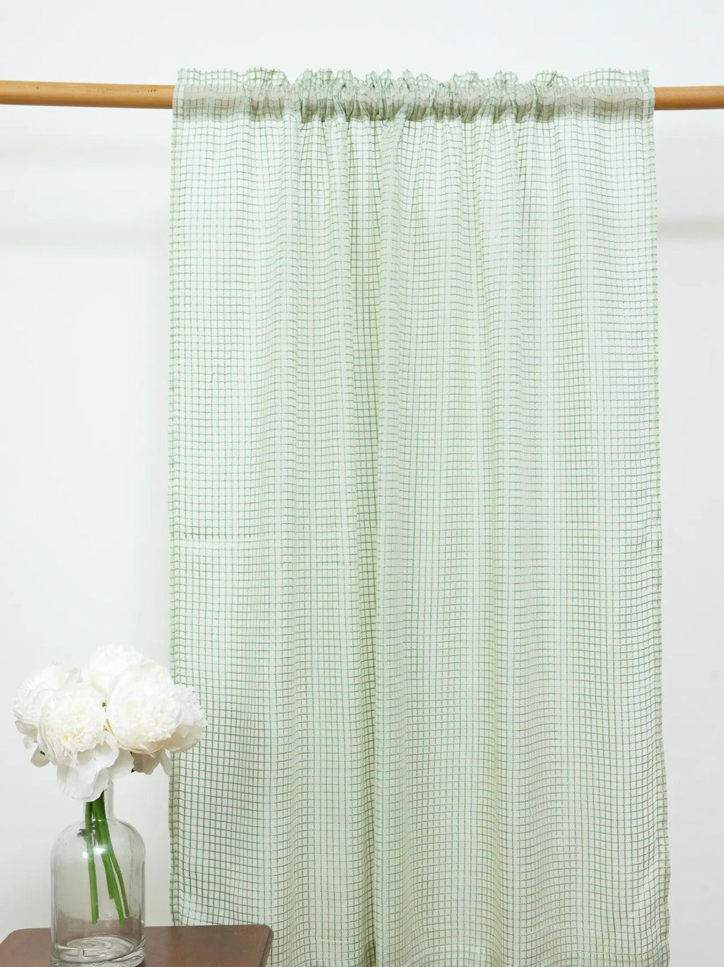 White sheer curtain with a fine green grid pattern and gathered rod pocket