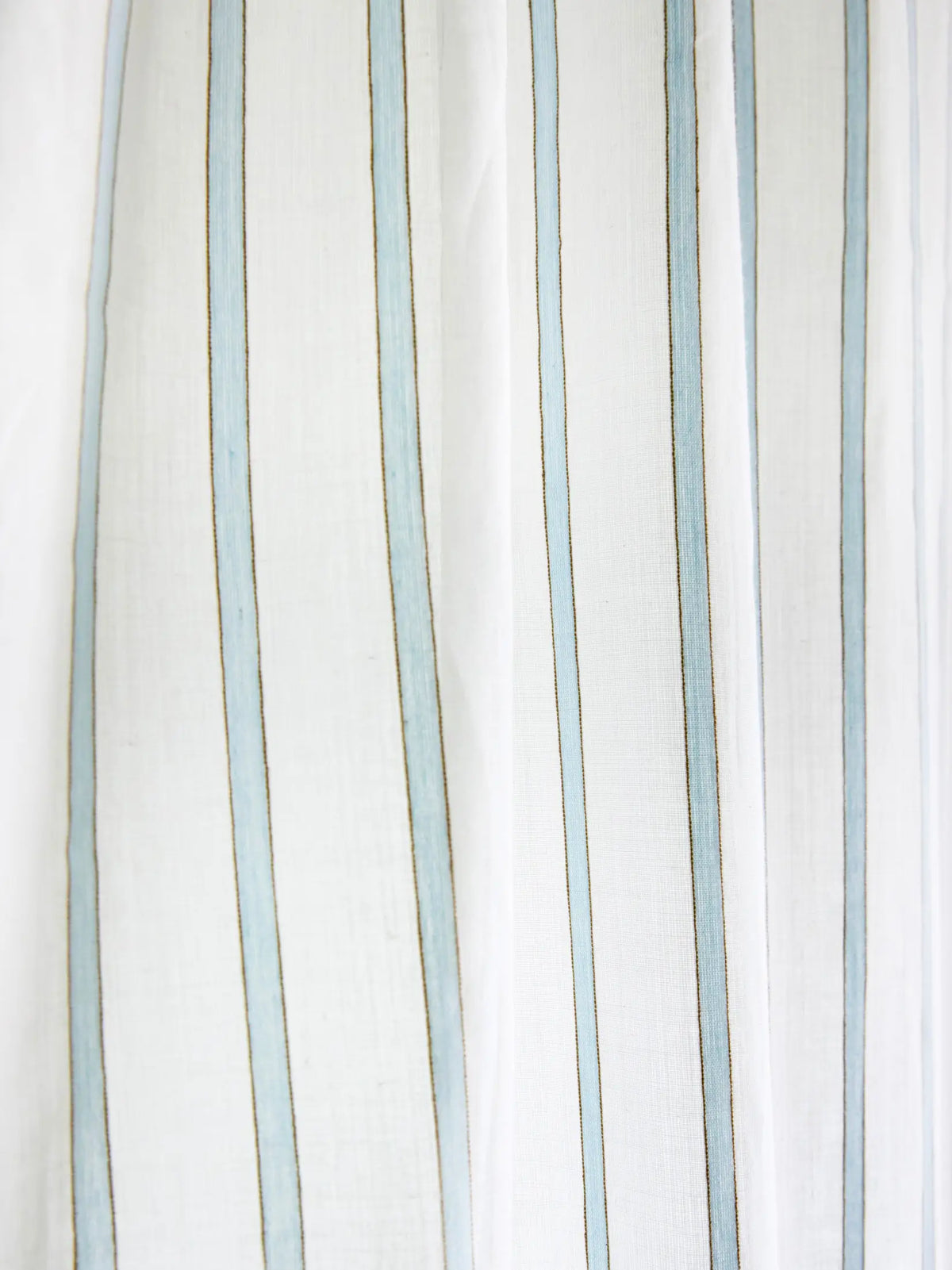 Close-up of narrow powder blue stripes on white sheer curtain fabric