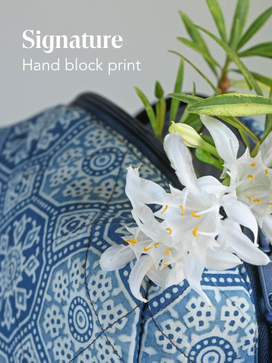 Close-up of blue geometric block-print fabric with the text Signature Hand block print