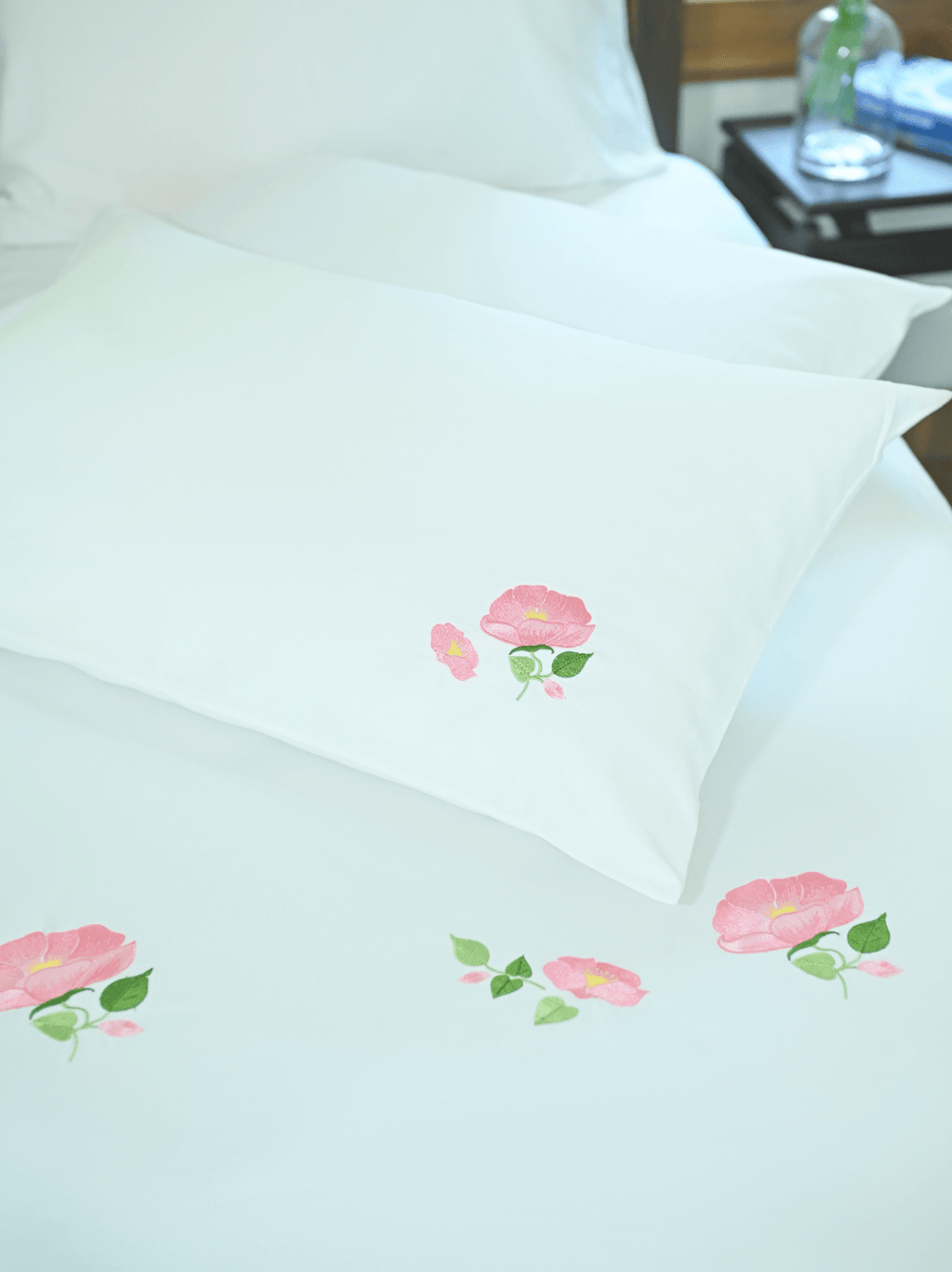 White bed sheet and pillowcase with pink poppy flower embroidery