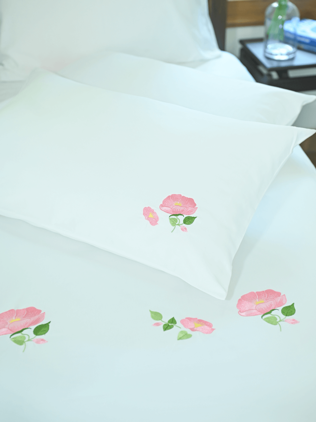 White bed sheet and pillowcase with pink poppy flower embroidery