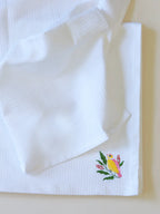 White waffle bath towel with yellow and pink bird embroidery